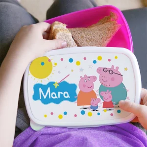 Copil folosind un lunchbox Peppa Pig personalizat cu nume pentru gustarea de la școală